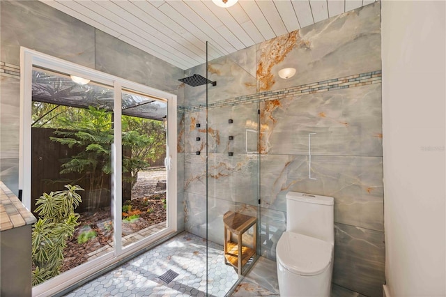 4916 Hidden Oaks Trl, Sarasota, FL 34232 - bathroom featuring a tile shower, tile walls, and toilet
