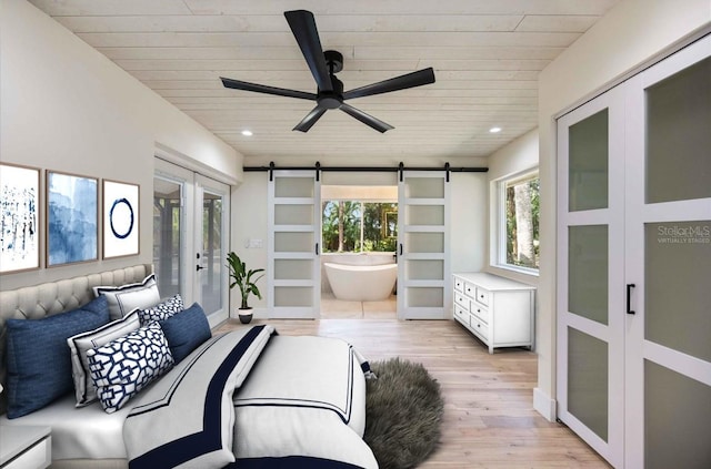 4916 Hidden Oaks Trl, Sarasota, FL 34232 - bedroom with wood ceiling, a barn door, light wood-style flooring, multiple windows, and french doors