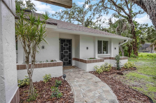 4916 Hidden Oaks Trl, Sarasota, FL 34232 - doorway to property with stucco siding and roof with shingles