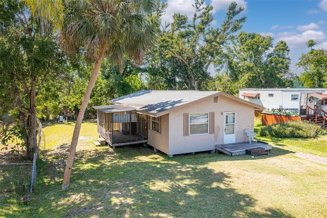rear view of house featuring fence, a wooden deck, and a yard