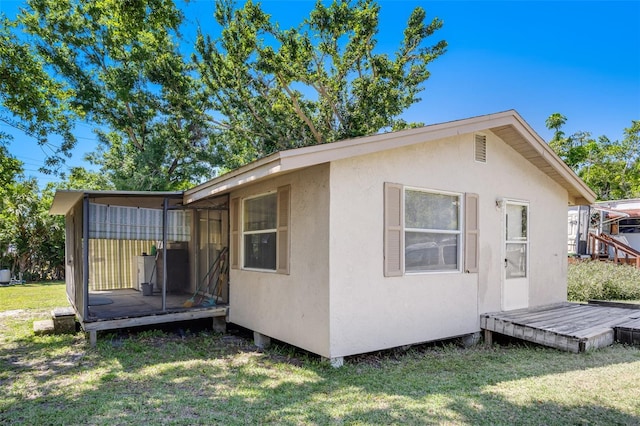 exterior space featuring a wooden deck and a lawn
