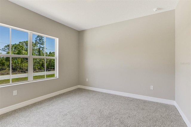 carpeted spare room with baseboards