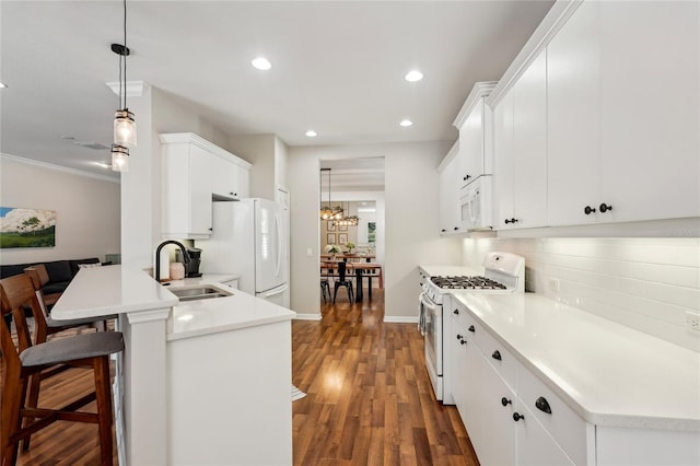 5023 Brickell Park Cv, Bradenton, FL 34211 - kitchen with white appliances, a sink, recessed lighting, a peninsula, and a kitchen bar