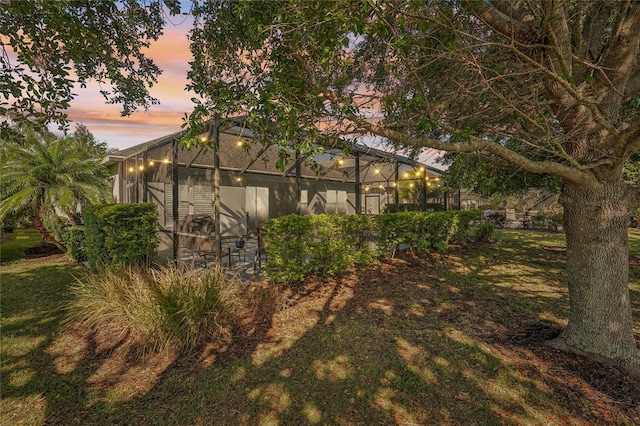 5023 Brickell Park Cv, Bradenton, FL 34211 - property exterior at dusk featuring glass enclosure and a lawn