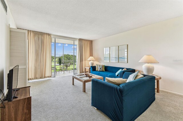 7461 W Country Club Dr N Unit 408, Sarasota, FL 34243 - carpeted living area with expansive windows, visible vents, and a textured ceiling