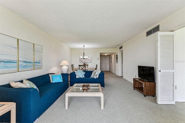 7461 W Country Club Dr N Unit 408, Sarasota, FL 34243 - carpeted living area with visible vents, a textured ceiling, and an inviting chandelier