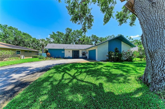 ranch-style home with a front yard, a garage, and driveway