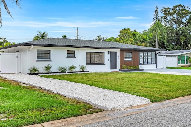 1921 Fern Ave, Sarasota, FL 34235 - single story home featuring a gate, fence, stucco siding, a front lawn, and a shingled roof