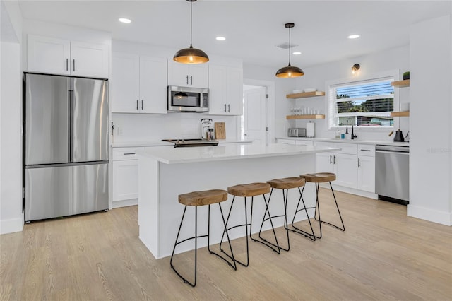 1921 Fern Ave, Sarasota, FL 34235 - kitchen with stainless steel appliances, open shelves, light countertops, white cabinets, and light wood-style floors