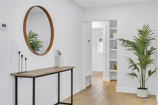 1921 Fern Ave, Sarasota, FL 34235 - hallway with light wood-style flooring, baseboards, and built in shelves
