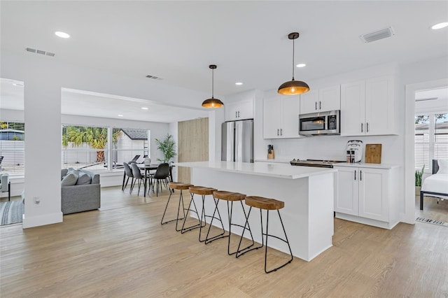 1921 Fern Ave, Sarasota, FL 34235 - kitchen featuring appliances with stainless steel finishes, a kitchen breakfast bar, healthy amount of natural light, white cabinets, and recessed lighting