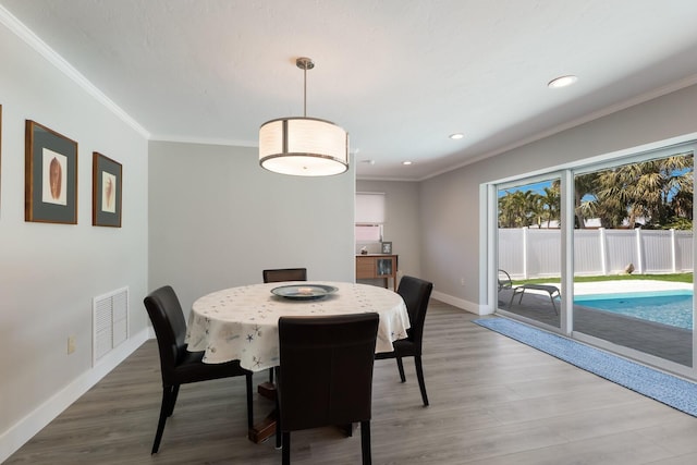 508 70th St, Holmes Beach, FL 34217 - dining area featuring visible vents, baseboards, crown molding, and wood finished floors