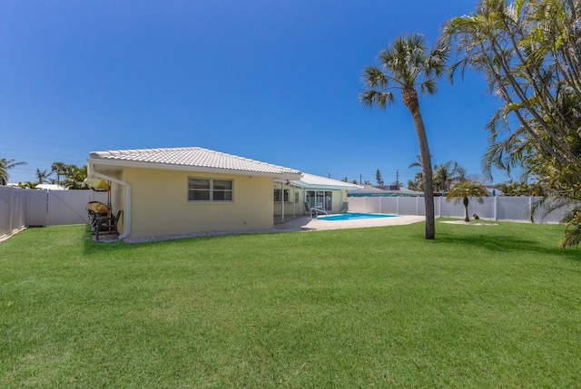 508 70th St, Holmes Beach, FL 34217 - rear view of house featuring a tiled roof, a fenced backyard, a fenced in pool, and a lawn