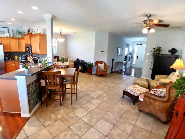 6631 63rd Ter E, Bradenton, FL 34203 - kitchen featuring appliances with stainless steel finishes, open floor plan, backsplash, ceiling fan, and a peninsula