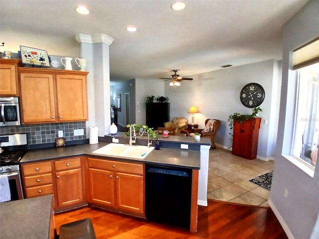 6631 63rd Ter E, Bradenton, FL 34203 - kitchen with a sink, appliances with stainless steel finishes, a peninsula, ceiling fan, and brown cabinets