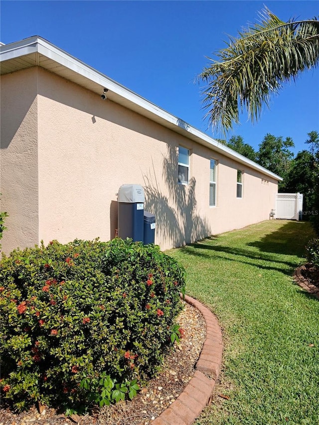 6631 63rd Ter E, Bradenton, FL 34203 - view of side of property featuring stucco siding and a lawn