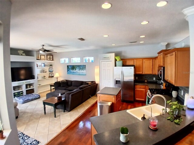 6631 63rd Ter E, Bradenton, FL 34203 - kitchen featuring appliances with stainless steel finishes, a sink, dark countertops, ceiling fan, and open floor plan