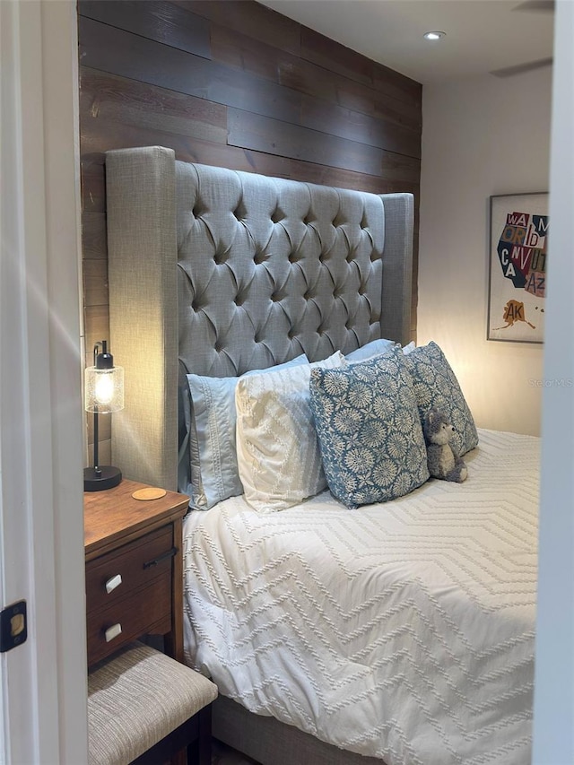 bedroom featuring wood walls