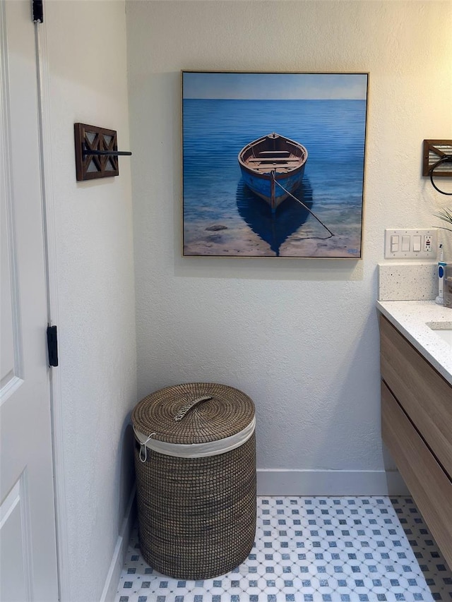 bathroom featuring tile patterned floors, vanity, and baseboards