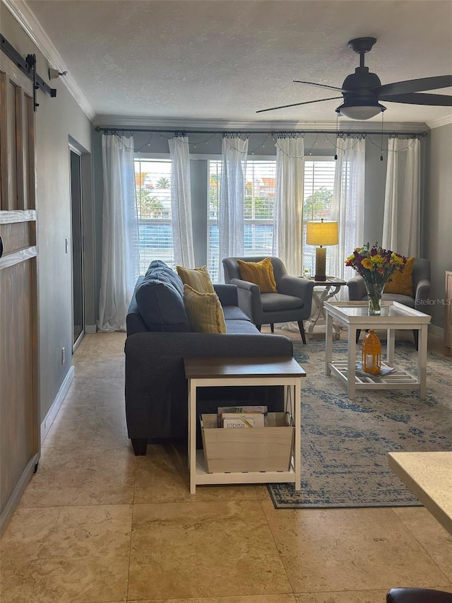 living room featuring plenty of natural light, ornamental molding, and a ceiling fan