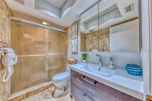 bathroom featuring visible vents, toilet, a shower stall, and vanity