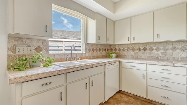 kitchen with tasteful backsplash, light countertops, white dishwasher, and a sink