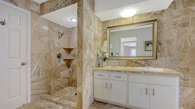 bathroom with tile walls, walk in shower, and vanity