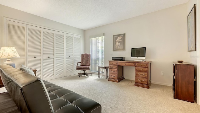 office featuring light colored carpet, a textured ceiling, and baseboards