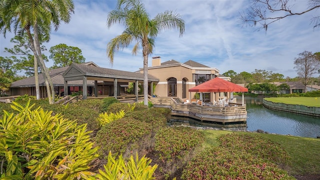 exterior space with a gazebo, a water view, and a chimney