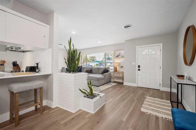entryway with light wood-style floors, baseboards, recessed lighting, and visible vents