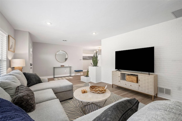 living room with recessed lighting, baseboards, visible vents, and wood finished floors