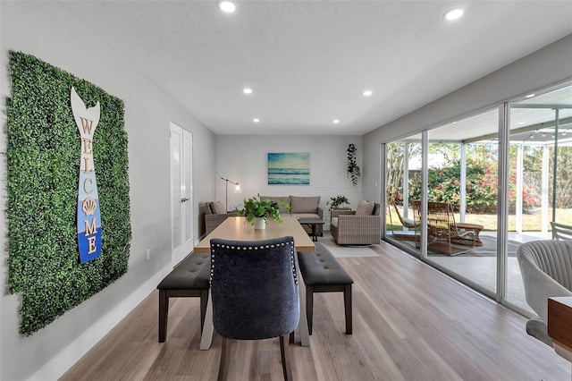 living room featuring recessed lighting, baseboards, and light wood-type flooring