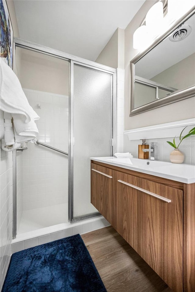 full bathroom featuring vanity, visible vents, and a shower stall
