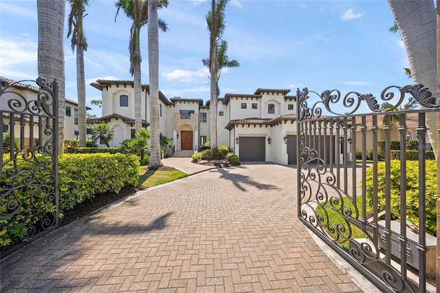 5830 Jamila River Dr, Venice, FL 34293 - mediterranean / spanish house with a gate, a tile roof, decorative driveway, a garage, and stucco siding