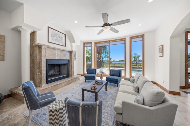 5830 Jamila River Dr, Venice, FL 34293 - living room featuring recessed lighting, arched walkways, a premium fireplace, baseboards, and ceiling fan