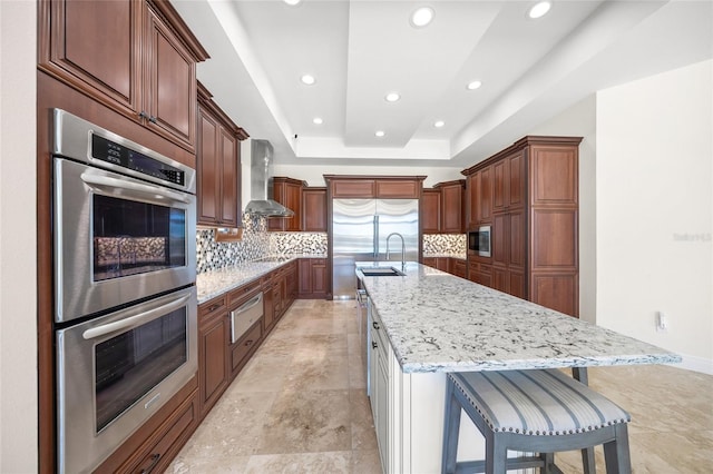 5830 Jamila River Dr, Venice, FL 34293 - kitchen with a sink, a warming drawer, wall chimney exhaust hood, decorative backsplash, and built in appliances