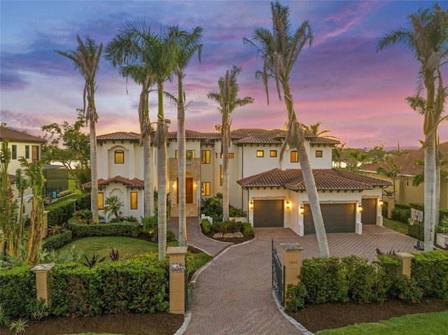 5830 Jamila River Dr, Venice, FL 34293 - mediterranean / spanish home featuring a garage, a tile roof, stucco siding, and decorative driveway