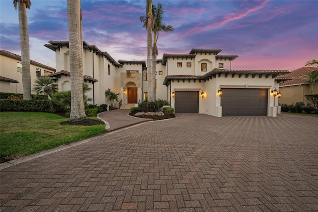 5830 Jamila River Dr, Venice, FL 34293 - mediterranean / spanish house with stucco siding, decorative driveway, a tiled roof, and a garage