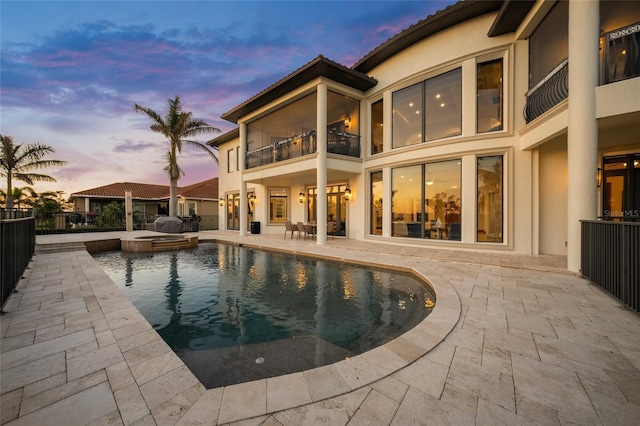 5830 Jamila River Dr, Venice, FL 34293 - rear view of house with a patio area, a balcony, fence, stucco siding, and a pool with connected hot tub