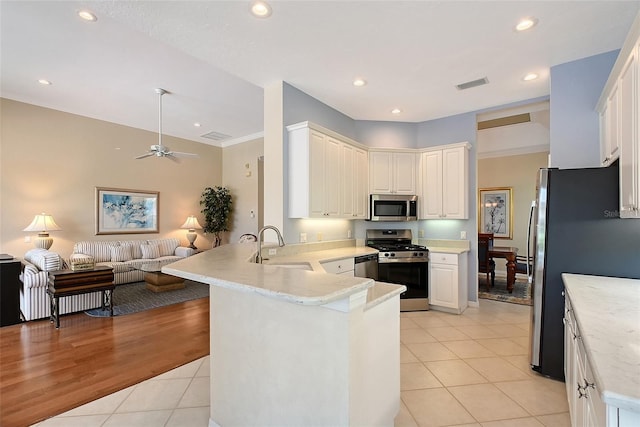 7528 Ascot Ct, Bradenton, FL 34201 - kitchen with appliances with stainless steel finishes, open floor plan, a peninsula, a sink, and light countertops