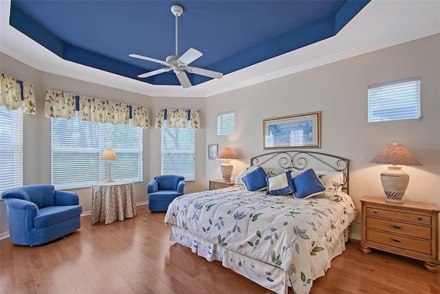 7528 Ascot Ct, Bradenton, FL 34201 - bedroom featuring a raised ceiling, wood finished floors, multiple windows, crown molding, and ceiling fan