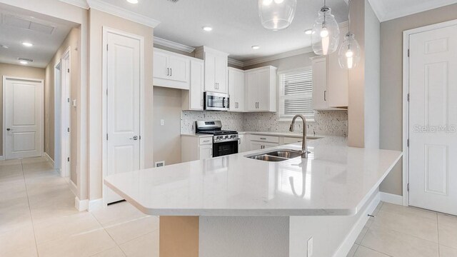 16202 Isola Pl, Bradenton, FL 34211 - kitchen featuring appliances with stainless steel finishes, a sink, ornamental molding, light tile patterned floors, and a peninsula