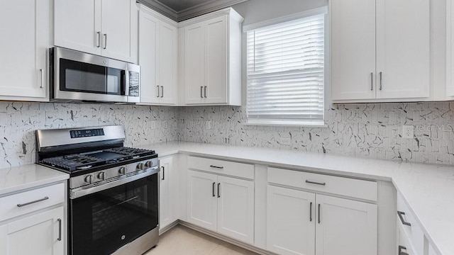 16202 Isola Pl, Bradenton, FL 34211 - kitchen featuring appliances with stainless steel finishes, white cabinetry, decorative backsplash, and light stone counters