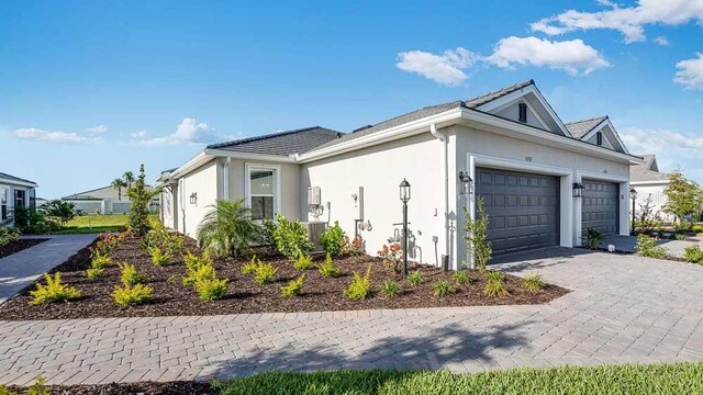 16202 Isola Pl, Bradenton, FL 34211 - view of front of home with an attached garage, stucco siding, and decorative driveway