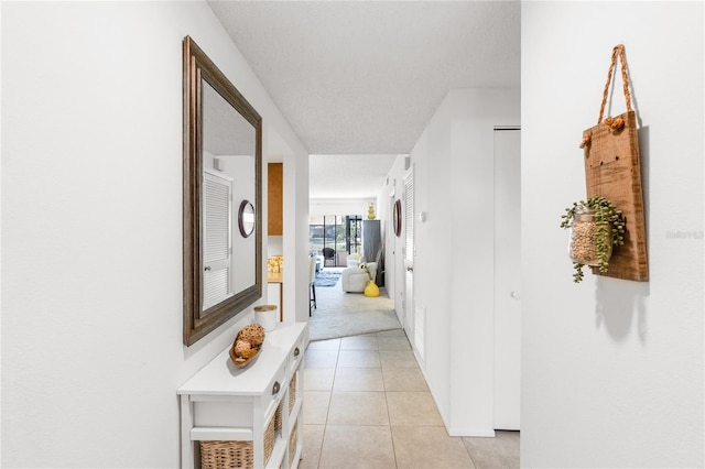hallway featuring light colored carpet and light tile patterned flooring