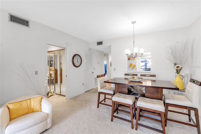 dining room with light carpet, a notable chandelier, and visible vents