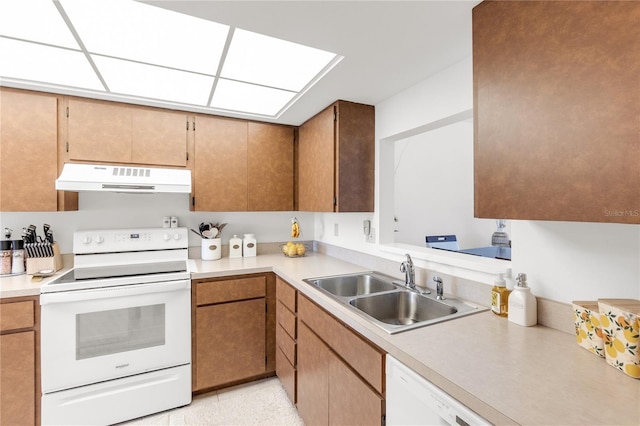 kitchen featuring a sink, light countertops, white appliances, and under cabinet range hood