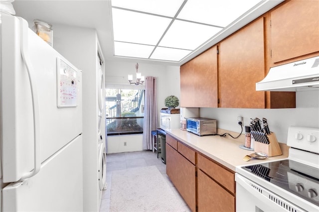 kitchen with light tile patterned floors, a notable chandelier, light countertops, white appliances, and under cabinet range hood