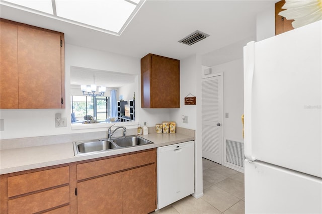 kitchen with white appliances, visible vents, a sink, and light tile patterned floors