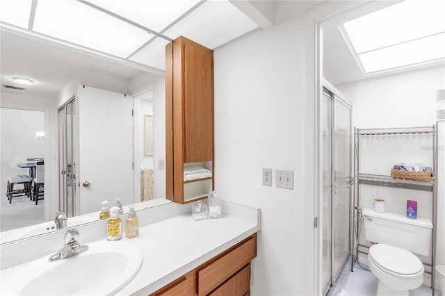 full bath featuring toilet, a stall shower, vanity, and visible vents